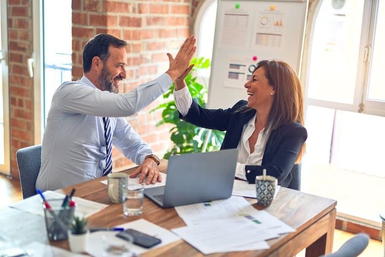 Team members high-fiving in office